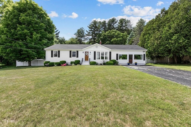 single story home with asphalt driveway, a chimney, and a shingled roof