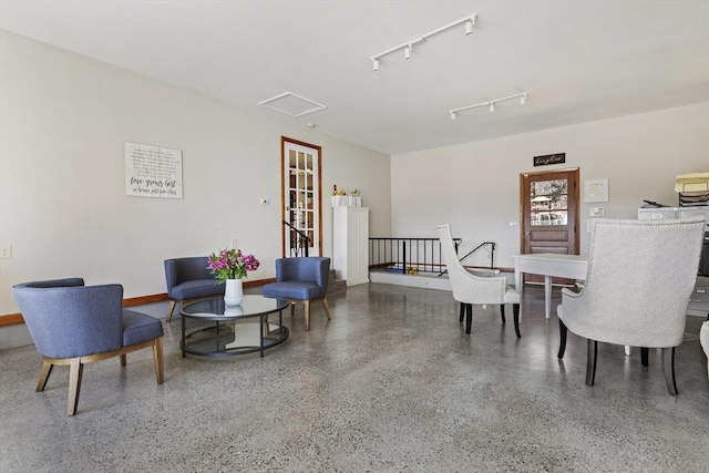 dining area featuring speckle patterned floor and track lighting