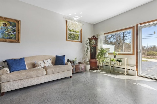 living area with speckle patterned floor, plenty of natural light, and baseboard heating