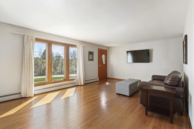 living area with wood finished floors and a baseboard radiator