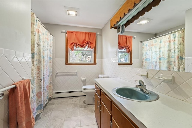 bathroom featuring baseboard heating, wainscoting, toilet, vanity, and tile patterned floors