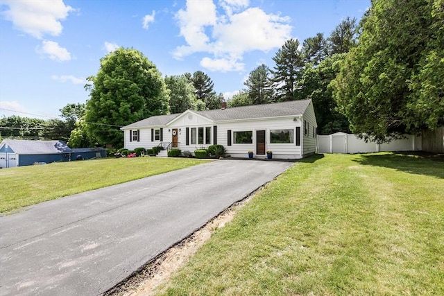 ranch-style home with asphalt driveway and a chimney