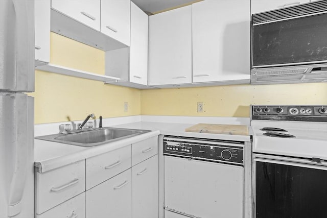 kitchen featuring light countertops, white appliances, a sink, and white cabinetry