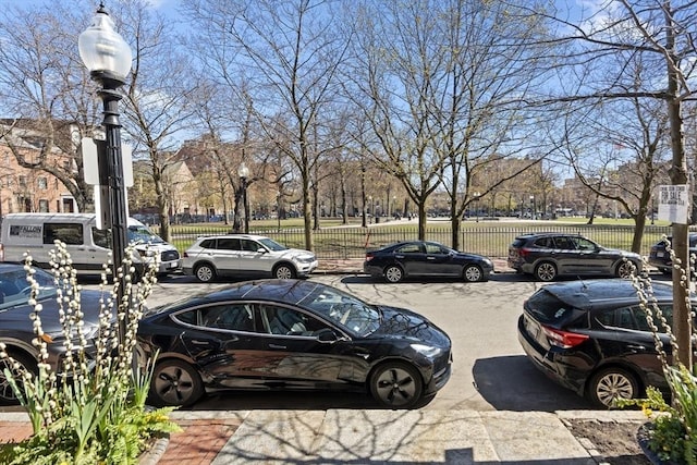 view of parking / parking lot featuring fence