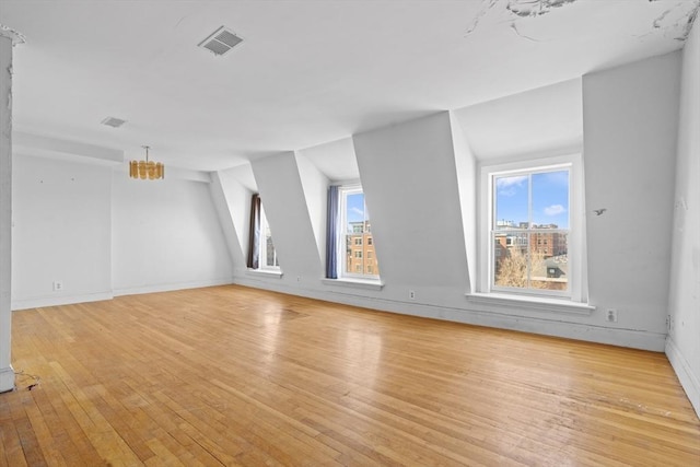 bonus room with baseboards, visible vents, and light wood-type flooring