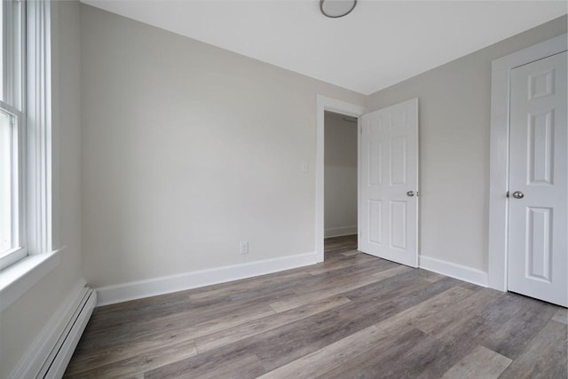 9 Garfield St, Dartmouth, MA 02748 - unfurnished bedroom with a baseboard radiator, wood finished floors, and baseboards