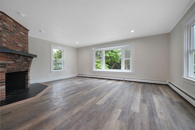 9 Garfield St, Dartmouth, MA 02748 - unfurnished living room featuring plenty of natural light, a brick fireplace, a baseboard radiator, wood finished floors, and crown molding