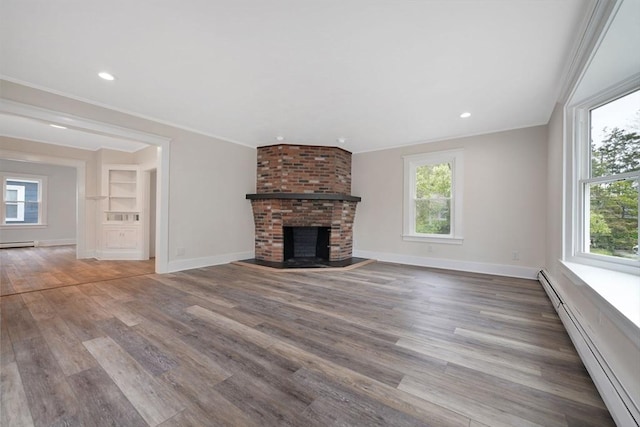 9 Garfield St, Dartmouth, MA 02748 - unfurnished living room with a baseboard heating unit, a brick fireplace, plenty of natural light, crown molding, and wood finished floors