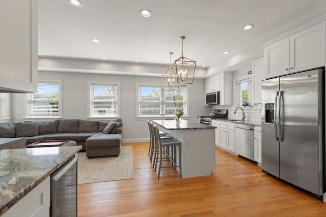 60 Starbird Ave Unit 2, Boston, MA 02131 - kitchen featuring stainless steel appliances, beverage cooler, open floor plan, a breakfast bar area, and dark stone counters