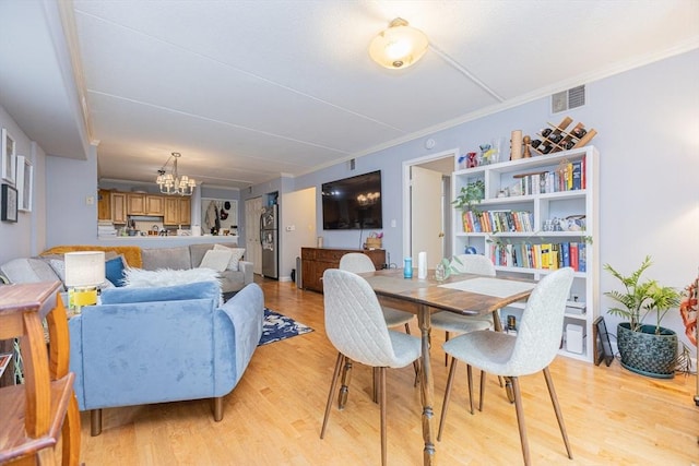 280 Harvard St Unit 1A, Cambridge, MA 02139 - dining space featuring a chandelier, light wood-type flooring, and ornamental molding