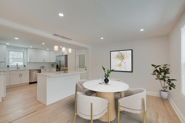 dining space with recessed lighting, baseboards, and light wood-type flooring