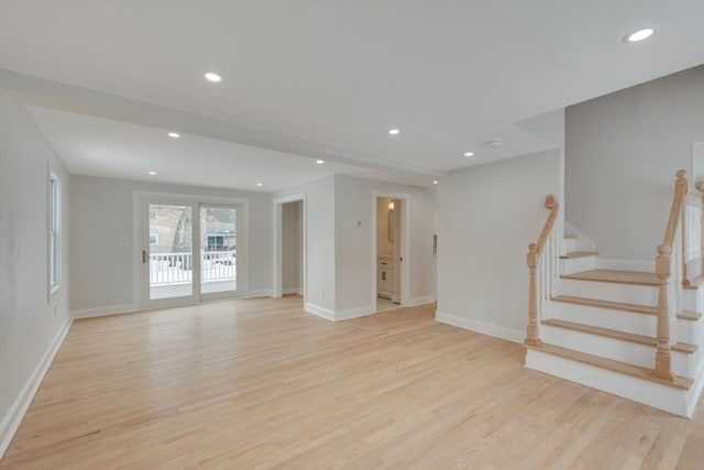 unfurnished living room with stairway, baseboards, recessed lighting, and light wood finished floors
