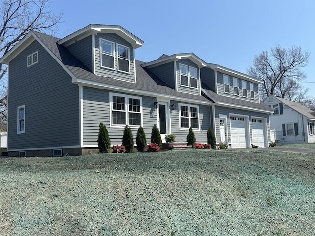 view of front of property featuring an attached garage, driveway, and a shingled roof