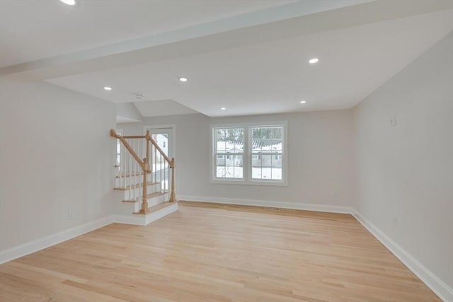 spare room featuring light wood-style floors, recessed lighting, stairs, and baseboards