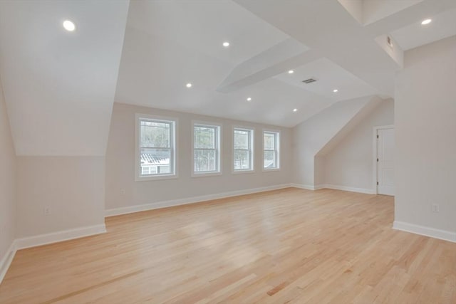 additional living space featuring recessed lighting, baseboards, lofted ceiling with beams, and light wood-type flooring