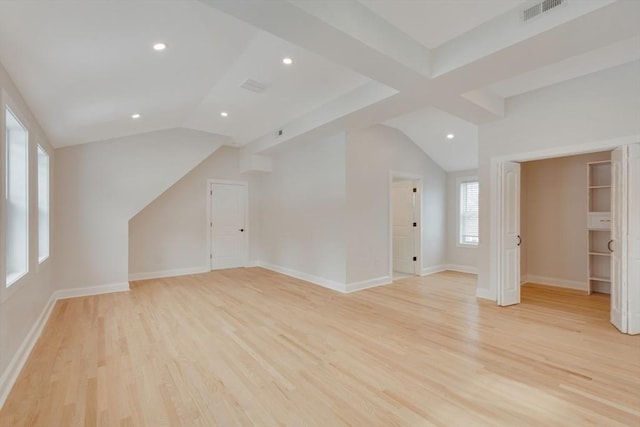 additional living space with visible vents, baseboards, lofted ceiling, and light wood-type flooring