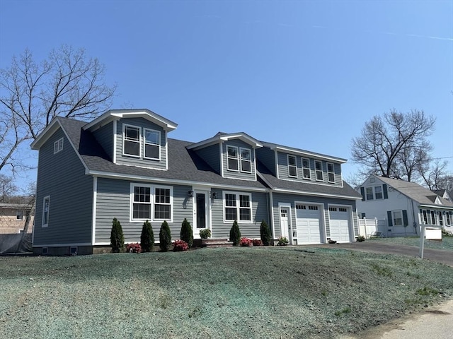 view of front of house with an attached garage, a shingled roof, driveway, and a front yard