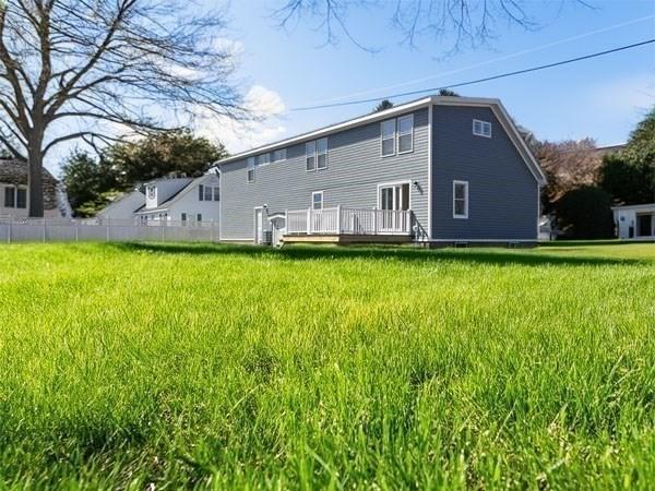 rear view of property with fence and a wooden deck