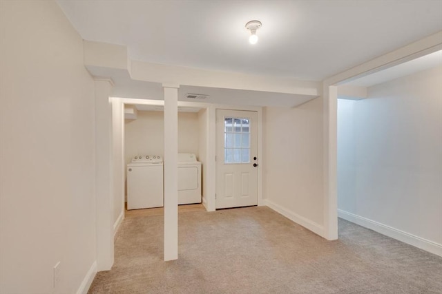 below grade area with separate washer and dryer, baseboards, visible vents, and light colored carpet