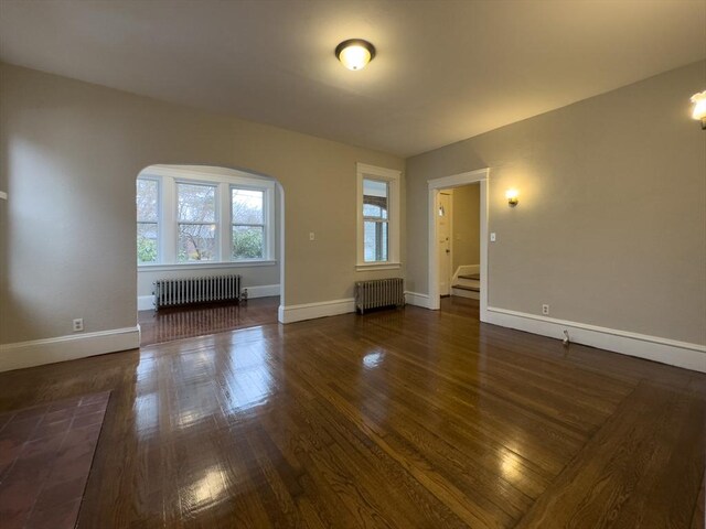 empty room with radiator and dark hardwood / wood-style floors