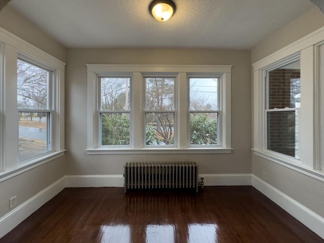 unfurnished sunroom featuring radiator heating unit