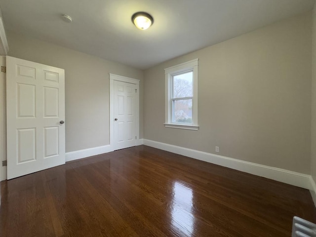 unfurnished bedroom with dark wood-type flooring and a closet