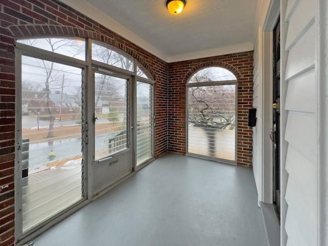 entryway with concrete flooring and brick wall