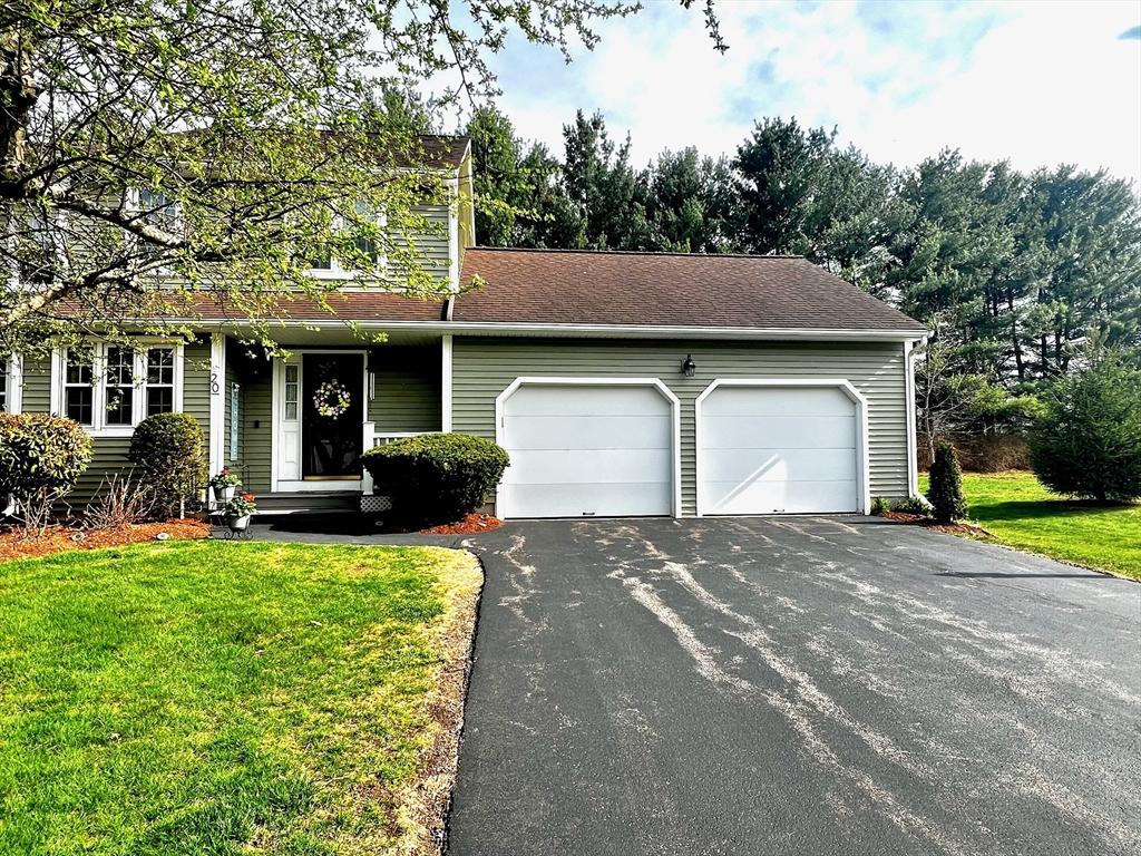 view of front facade featuring a garage, aphalt driveway, and a front yard