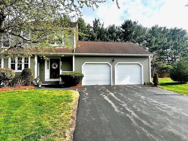 view of front facade featuring a garage, aphalt driveway, and a front yard