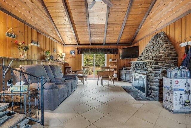 living room featuring wooden walls, a fireplace, beam ceiling, and wooden ceiling