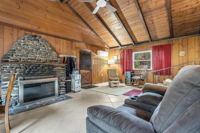 living room with ceiling fan, beamed ceiling, wooden walls, wooden ceiling, and a fireplace