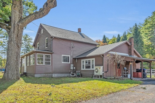 exterior space with ac unit and a lawn