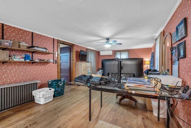 home office with ceiling fan, crown molding, and light hardwood / wood-style floors