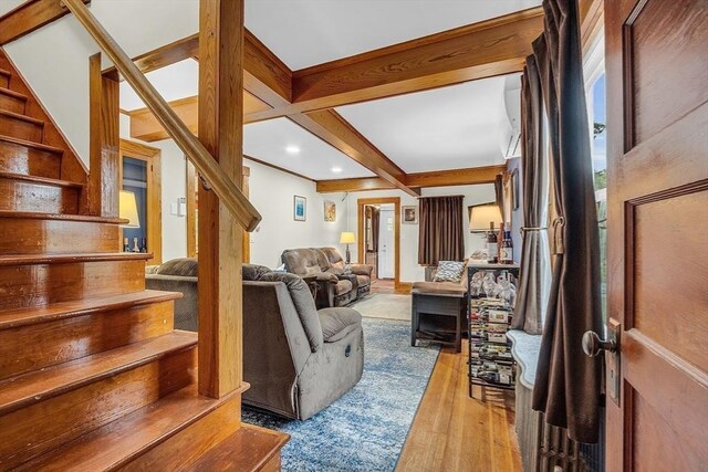 living room with coffered ceiling, beamed ceiling, and light hardwood / wood-style floors