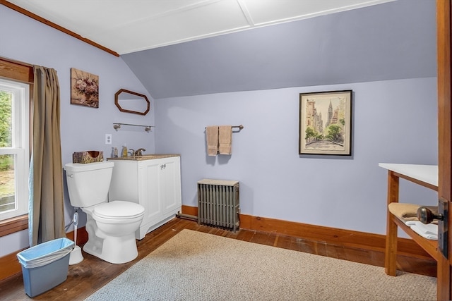 bathroom featuring sink, vaulted ceiling, hardwood / wood-style floors, radiator heating unit, and toilet