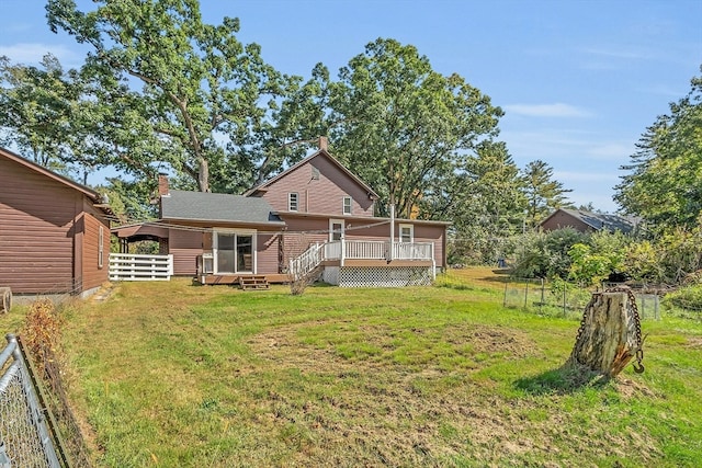 back of house featuring a wooden deck, a sunroom, and a yard