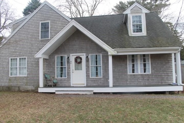 cape cod house featuring a front lawn