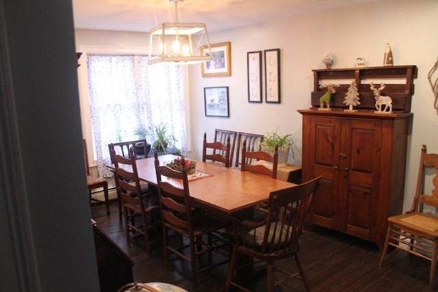 dining room featuring dark wood-type flooring, a chandelier, and baseboard heating