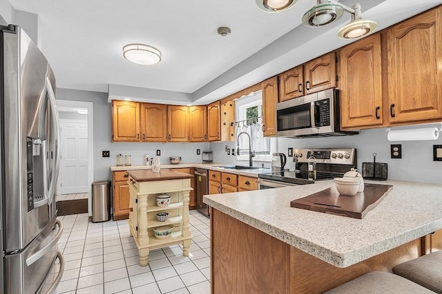 kitchen featuring kitchen peninsula, a breakfast bar, stainless steel appliances, and sink