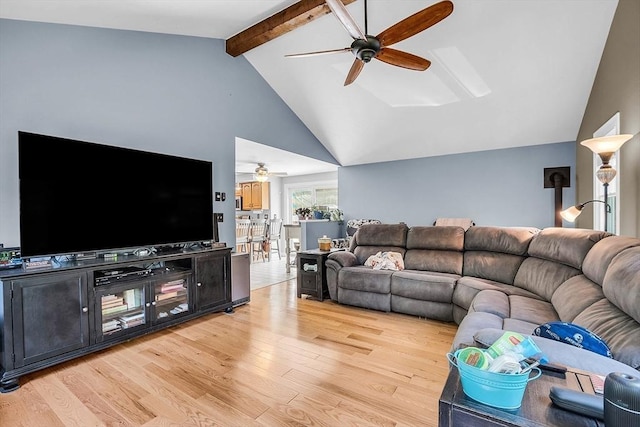 living room with ceiling fan, lofted ceiling with beams, and light wood-type flooring