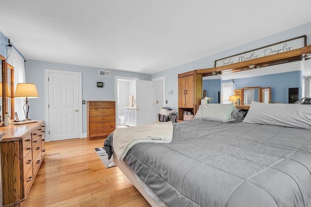 bedroom featuring light wood-type flooring and ensuite bathroom