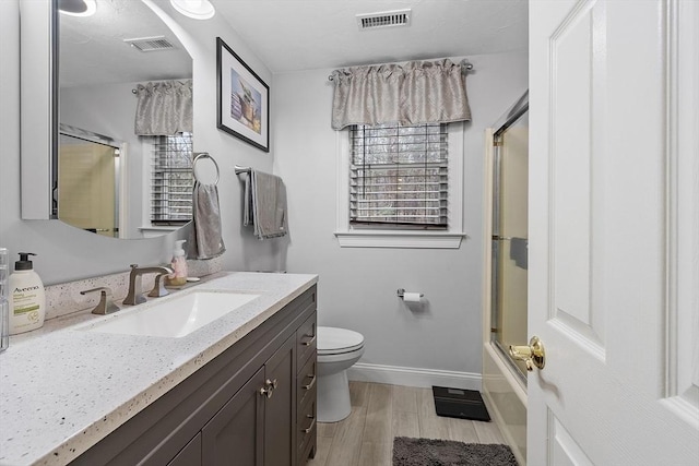 full bathroom with vanity, toilet, and shower / bath combination with glass door