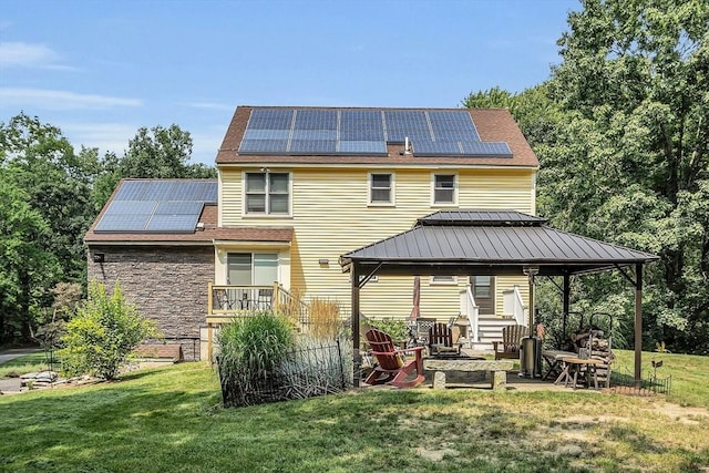 rear view of house with a gazebo, solar panels, a patio area, and a yard