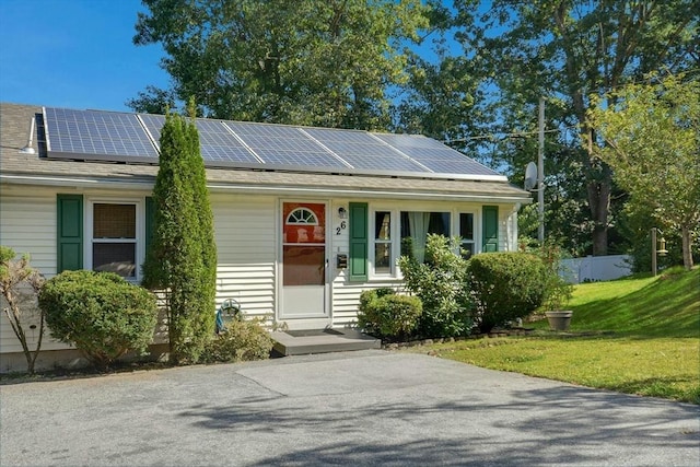 ranch-style home with roof mounted solar panels