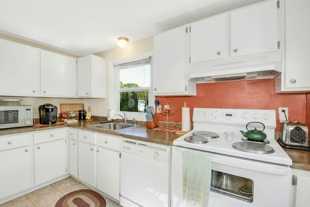 kitchen with white appliances, under cabinet range hood, a sink, white cabinets, and light tile patterned floors
