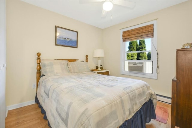 bedroom featuring a baseboard radiator, wood finished floors, cooling unit, and baseboards