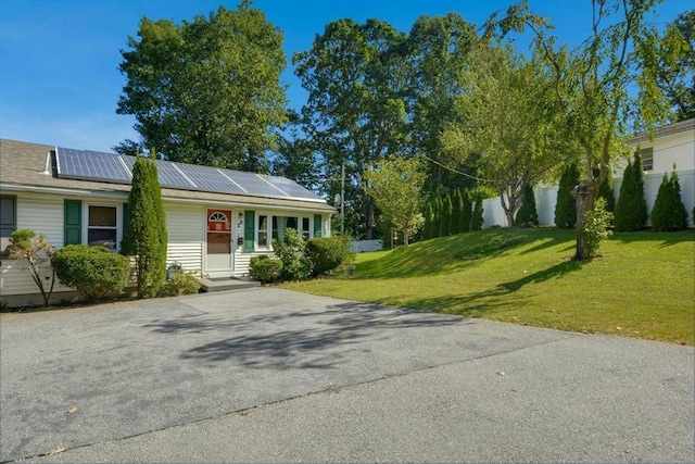view of front of property with solar panels and concrete driveway