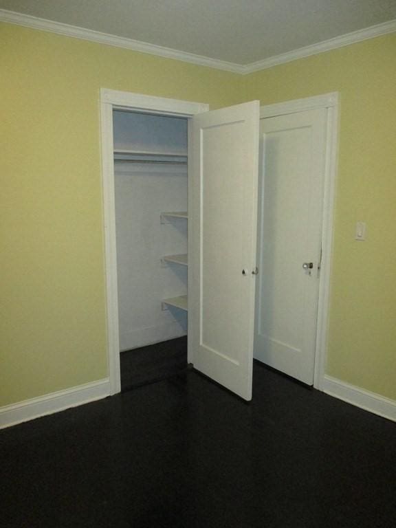 unfurnished bedroom featuring ornamental molding and a closet