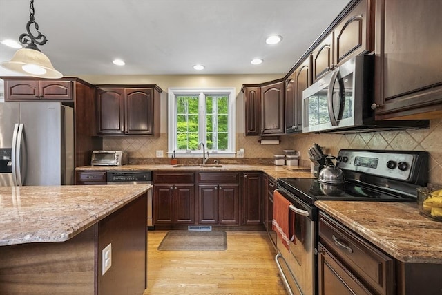 53 Arnold Way, Uxbridge, MA 01569 - kitchen with stainless steel appliances, light stone counters, decorative light fixtures, dark brown cabinets, and recessed lighting