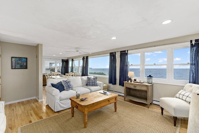 125 Seaview Dr, Plymouth, MA 02360 - living room featuring a baseboard heating unit, baseboards, a water view, recessed lighting, and light wood-style flooring